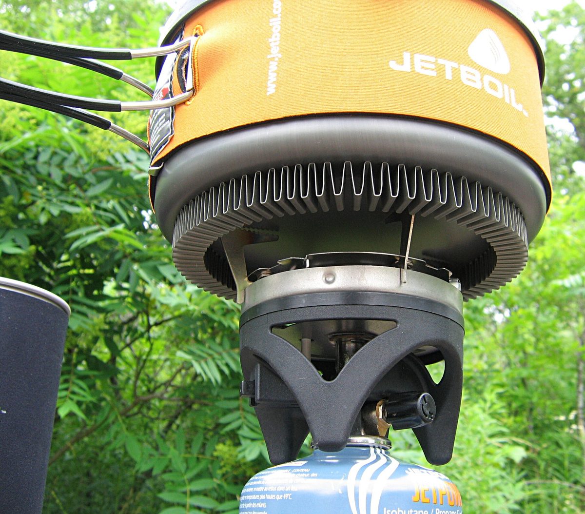 An integrated canister stove with a pot sitting on the burner.